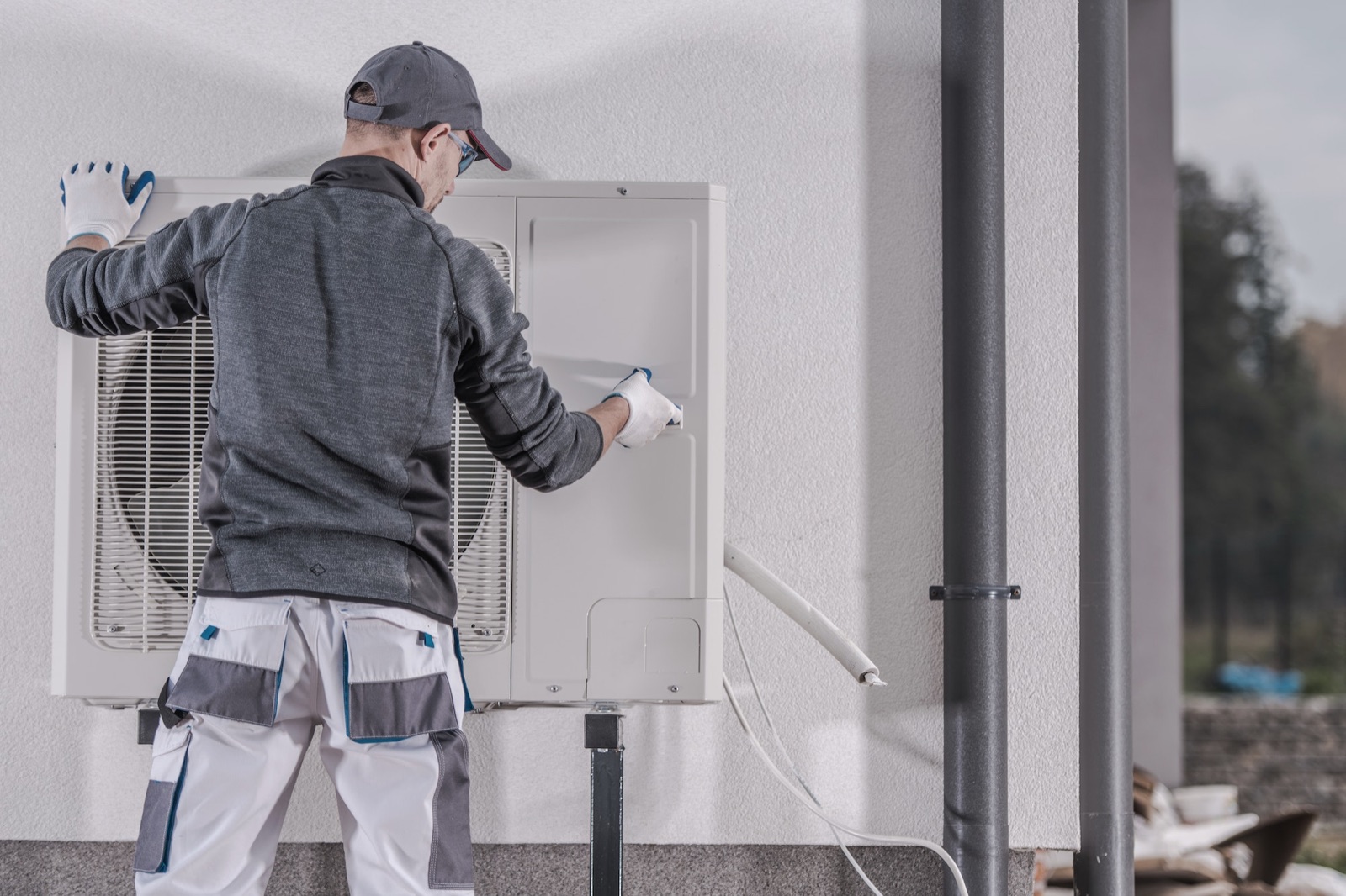 Monteur an der Außeneinheit einer Wärmepumpe